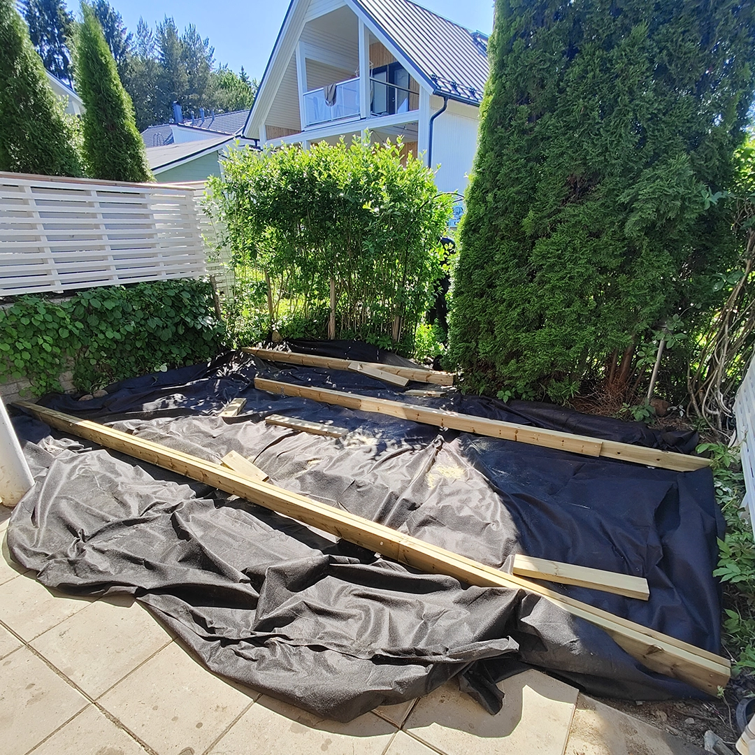 Terassin rakentamista takapihalla. Rakennustarvikkeita takapihalla.
